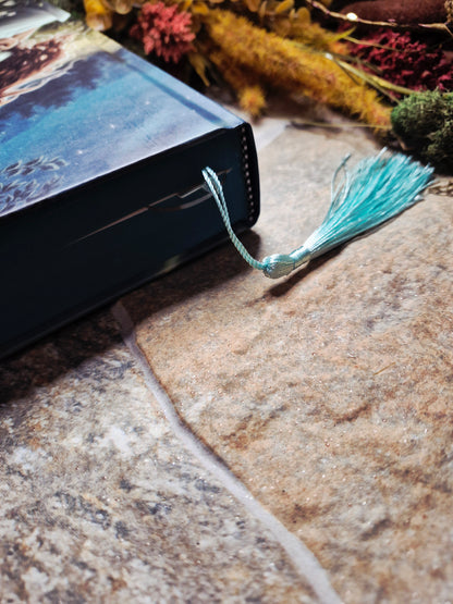 closed book with a tassel sticking out on a stone background. 
