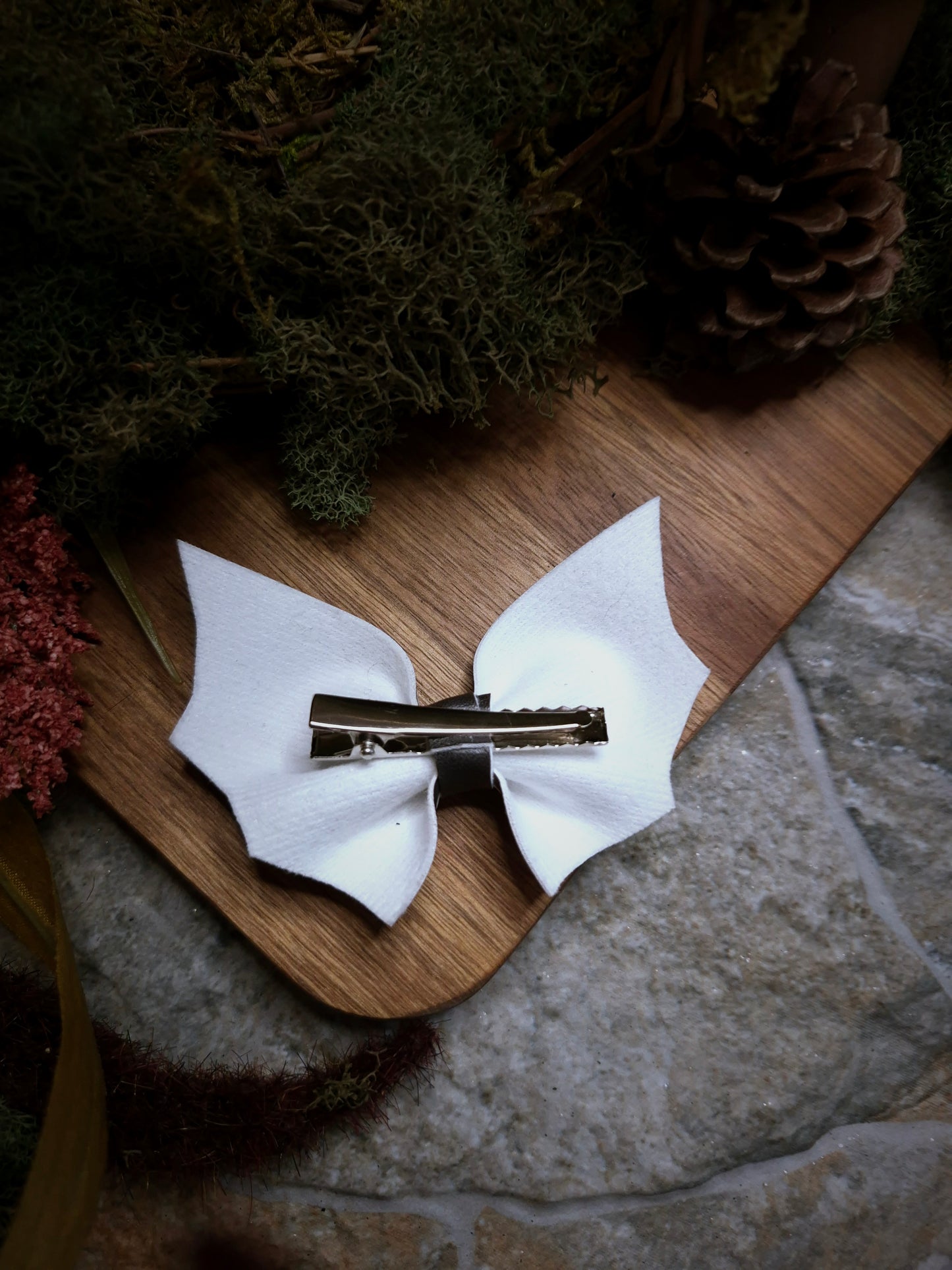 back of Beetlejuice stripe bat bow on a wood and stone background 