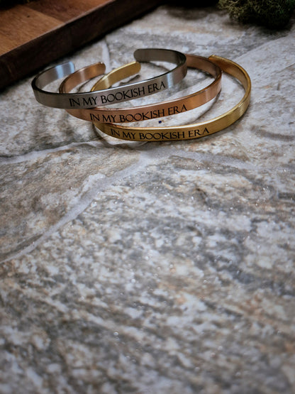 Stack of In My Bookish Era bracelets on a stone background. 