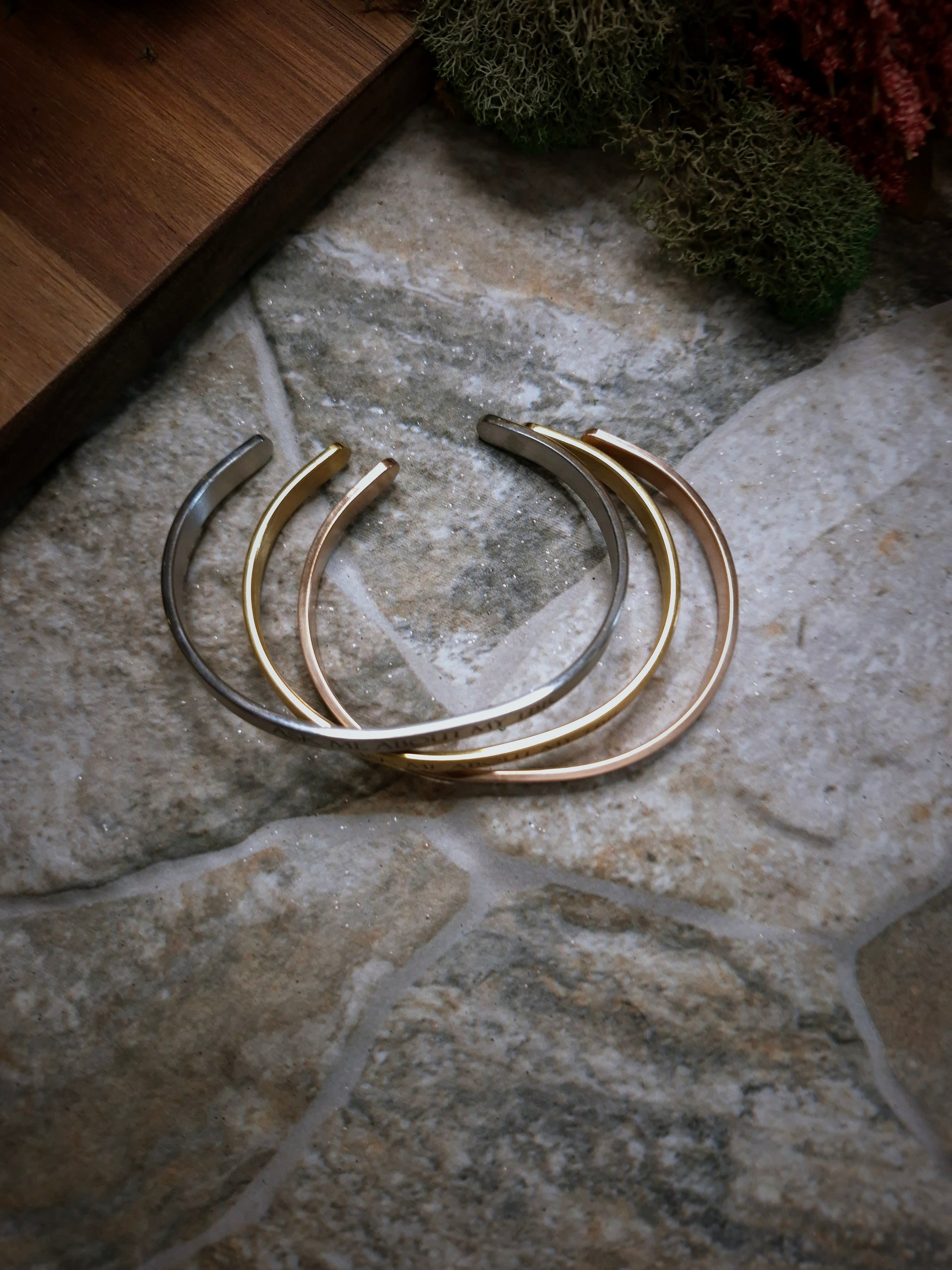 Stack of adjustable bracelets on a stone background. 