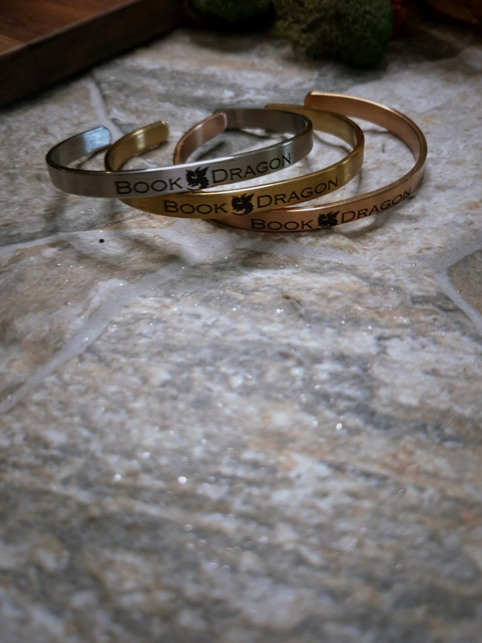 Stack of book dragon bracelets on a stone background. 