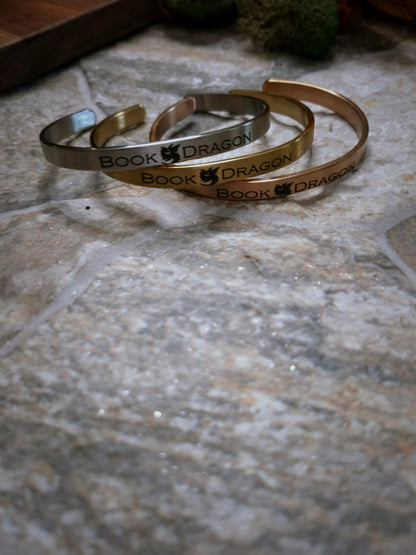 Stack of book dragon bracelets on a stone background. 