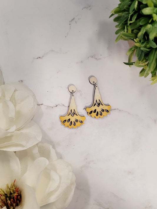 foxglove earrings on a marble background surrounded by foliage.