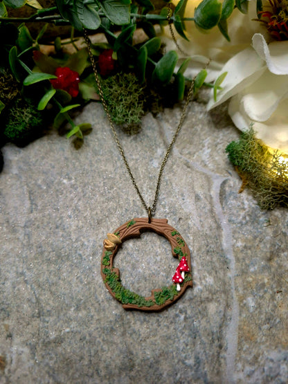 Mushroom Wreath Necklace on a stone background surrounded by foliage
