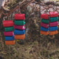 video close up of Bookstack earrings made of polymer clay in two sizes sits on a mossy background 