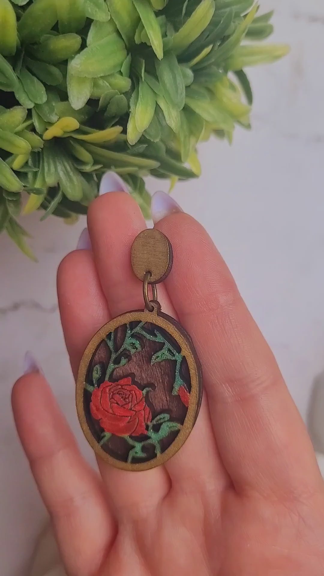 video close up of Spring Court Earrings on a marble background surrounded by foliage