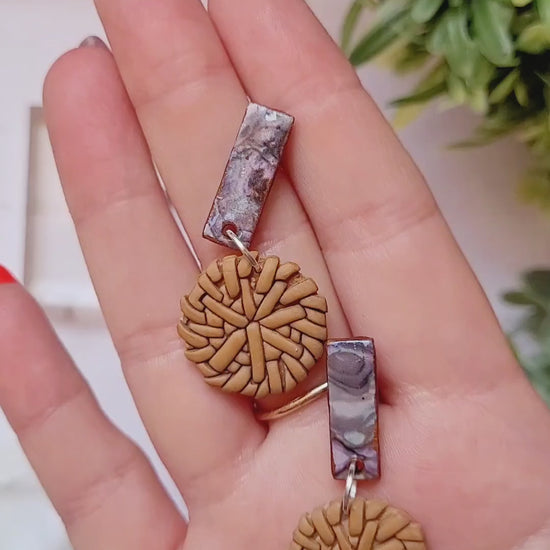 video close up of Faux rattan and shell earrings on a marble background. 