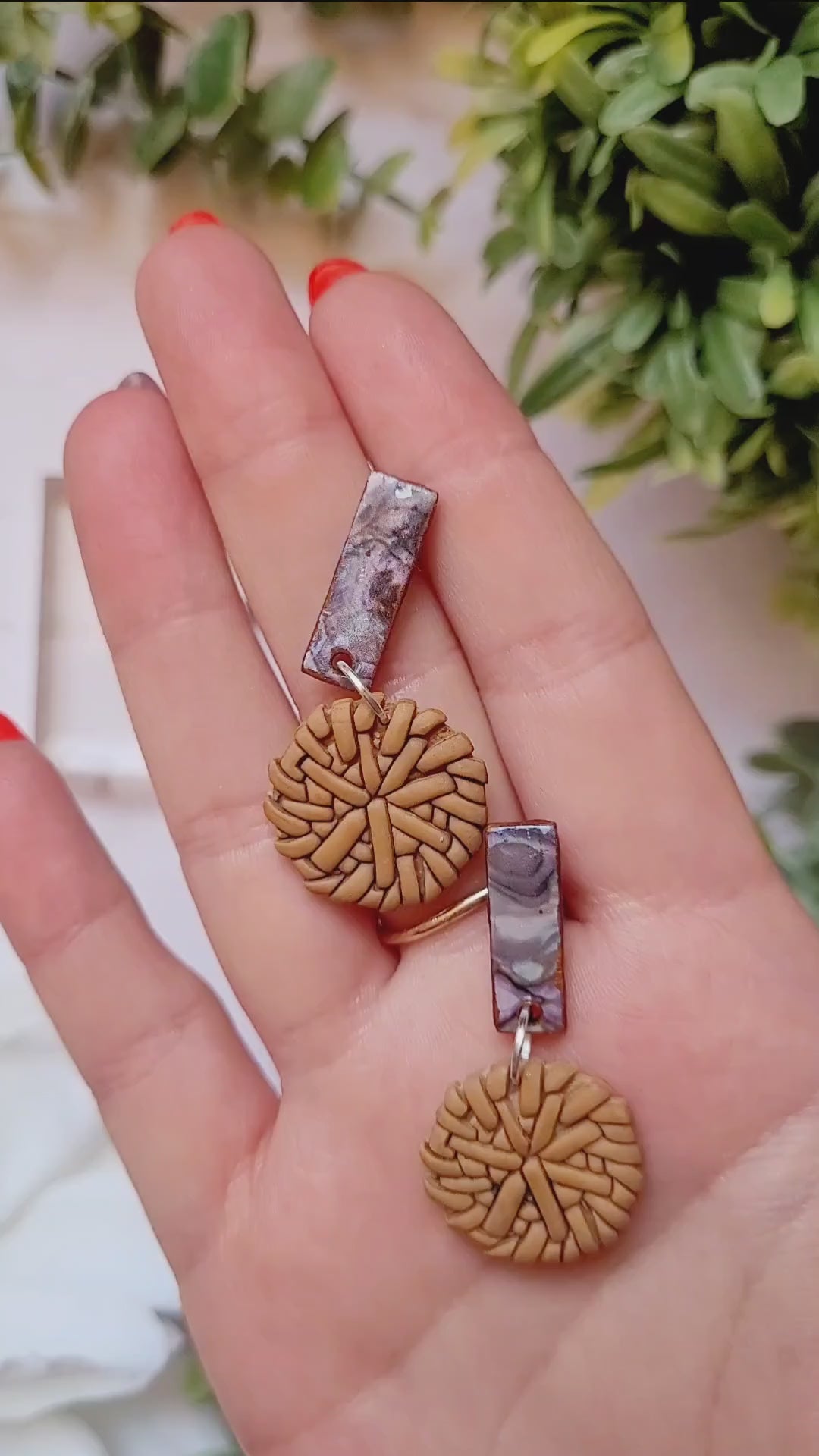video close up of Faux rattan and shell earrings on a marble background. 