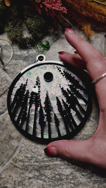 video of forest suncatcher on a stone background surrounded by foliage 
