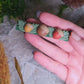 video close up of acorn clips on a stone background surrounded by foliage