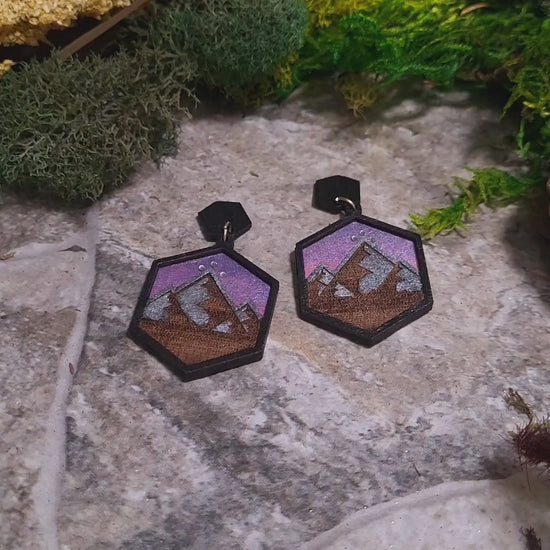 video close up Night Court Earring on a stone background surrounded by foliage