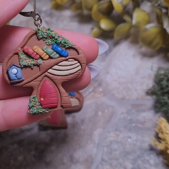 video close up of Mushroom Shelf Earring on a stone background surrounded by foliage. 