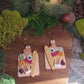 video close up of charcuterie board earrings on a wood background. 