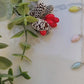 video close up of Christmas lights necklace on a marble background surrounded by foliage.