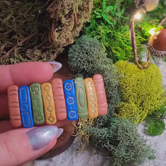 video close up of Bookstack barrette on a wood and stone background surrounded by moss