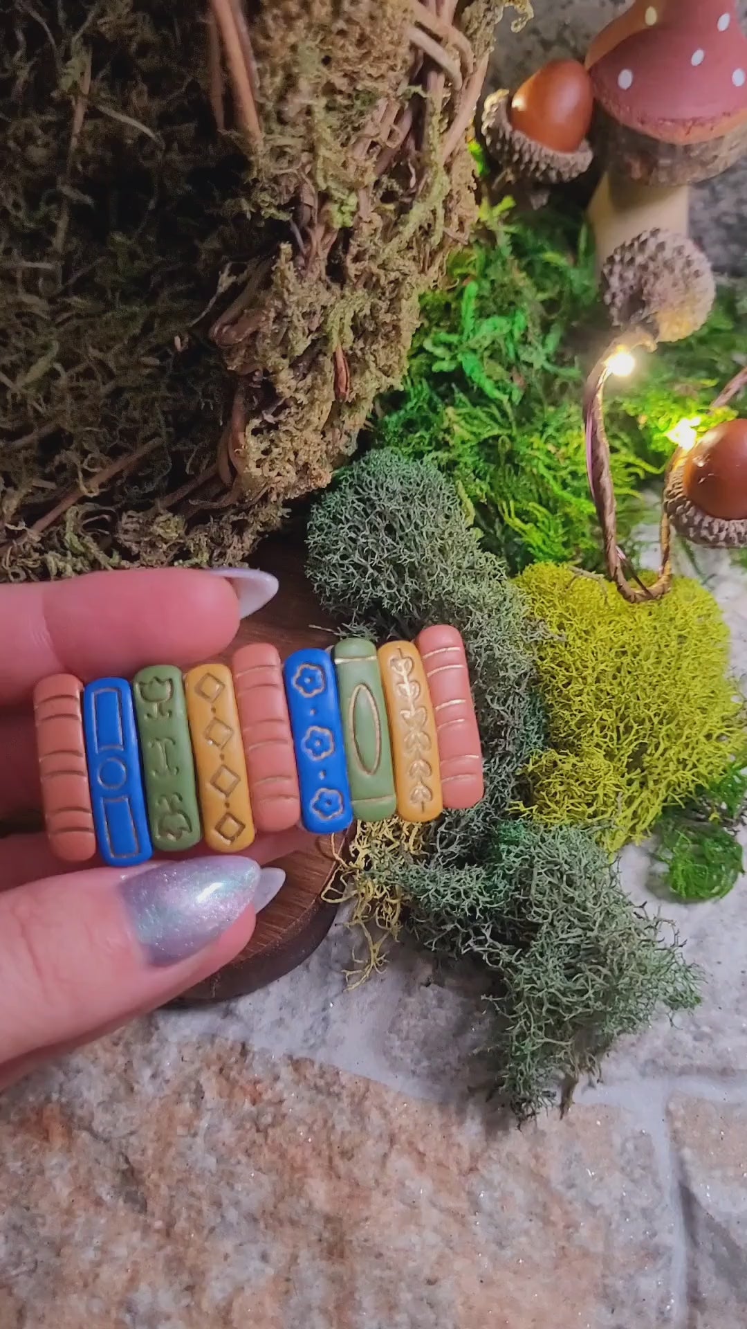 video close up of Bookstack barrette on a wood and stone background surrounded by moss