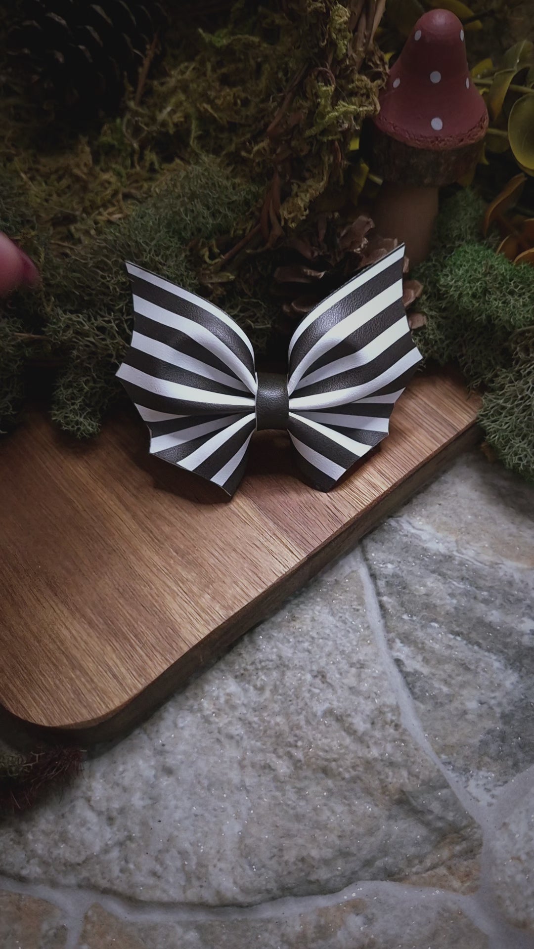 video of Beetlejuice stripe bat bow on a wood and stone background 