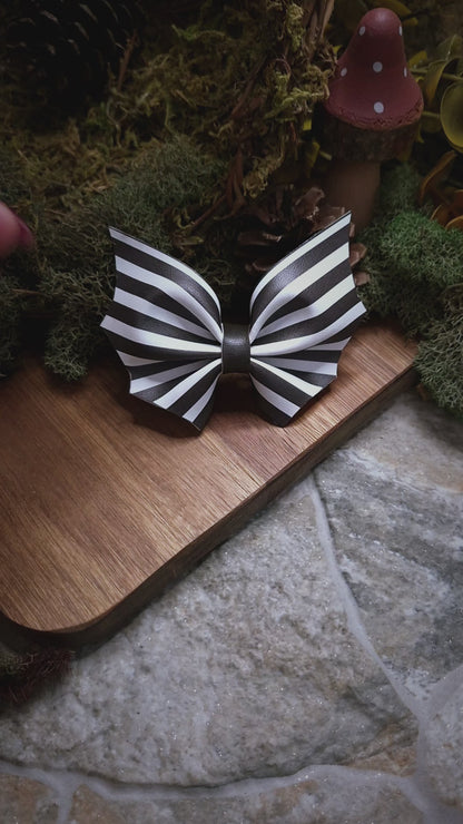 video of Beetlejuice stripe bat bow on a wood and stone background 