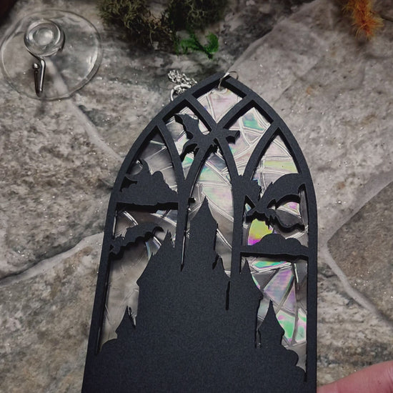 video of Gothic Dragon Window Suncatcher on a stone background surrounded by foliage 