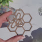 video or Bee suncatcher on marble background surrounded by foliage.