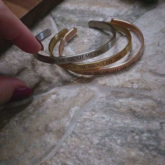 video of Ask Me About My TBR bracelets on a stone background 
