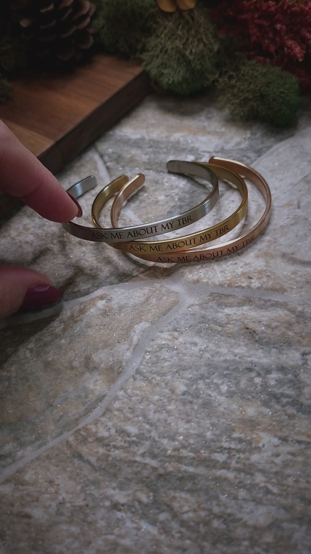 video of Ask Me About My TBR bracelets on a stone background 
