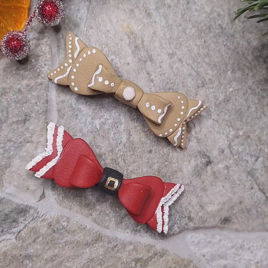 Video close up of Christmas Bow Barrettes on a  stone background surrounded by foliage