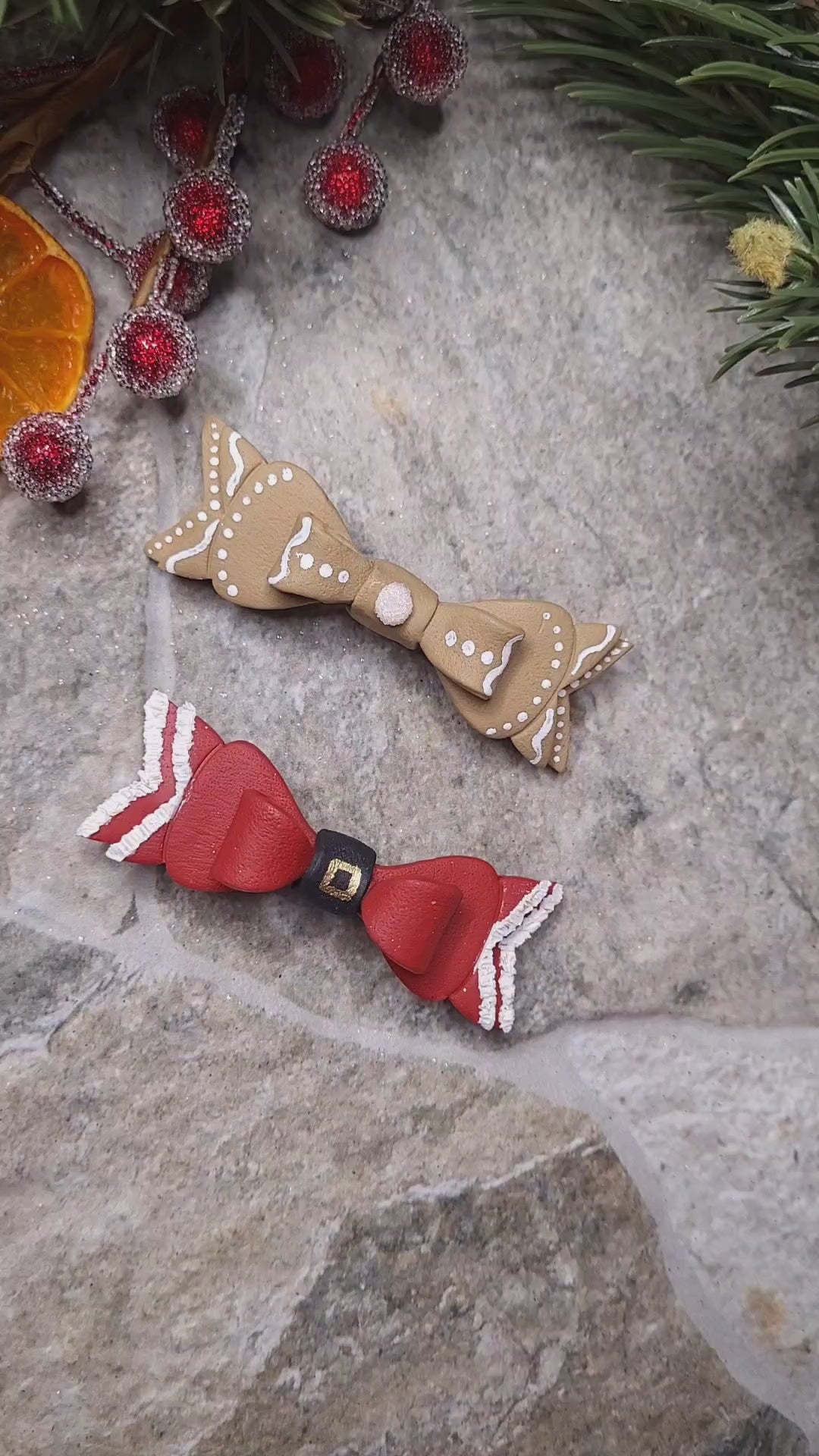 Video close up of Christmas Bow Barrettes on a  stone background surrounded by foliage