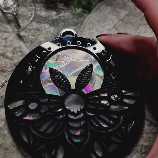 video of Celestial Moth suncatcher on a stone background surrounded by foliage
