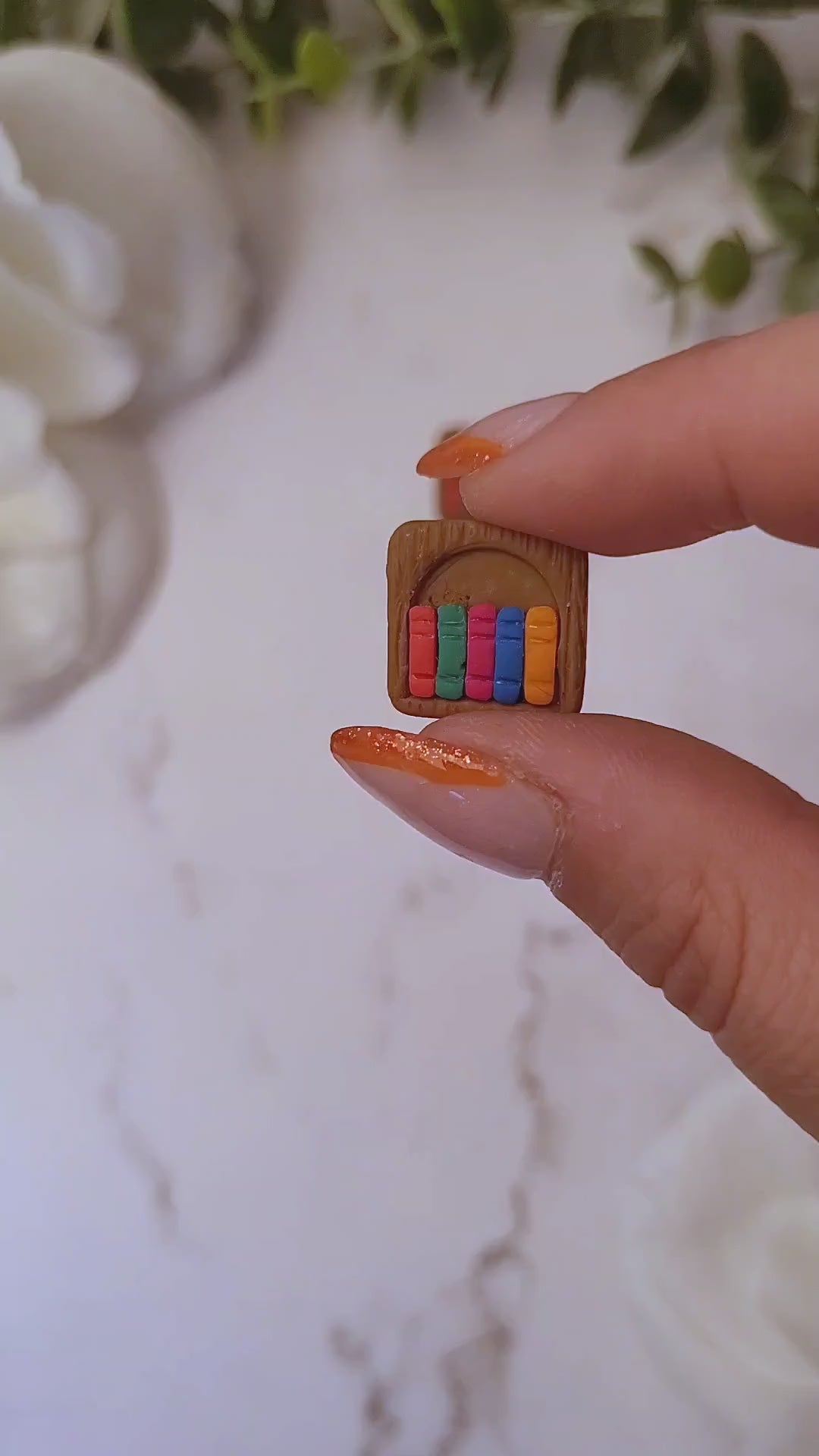 video close up of bookshelf stud made of polymer clay