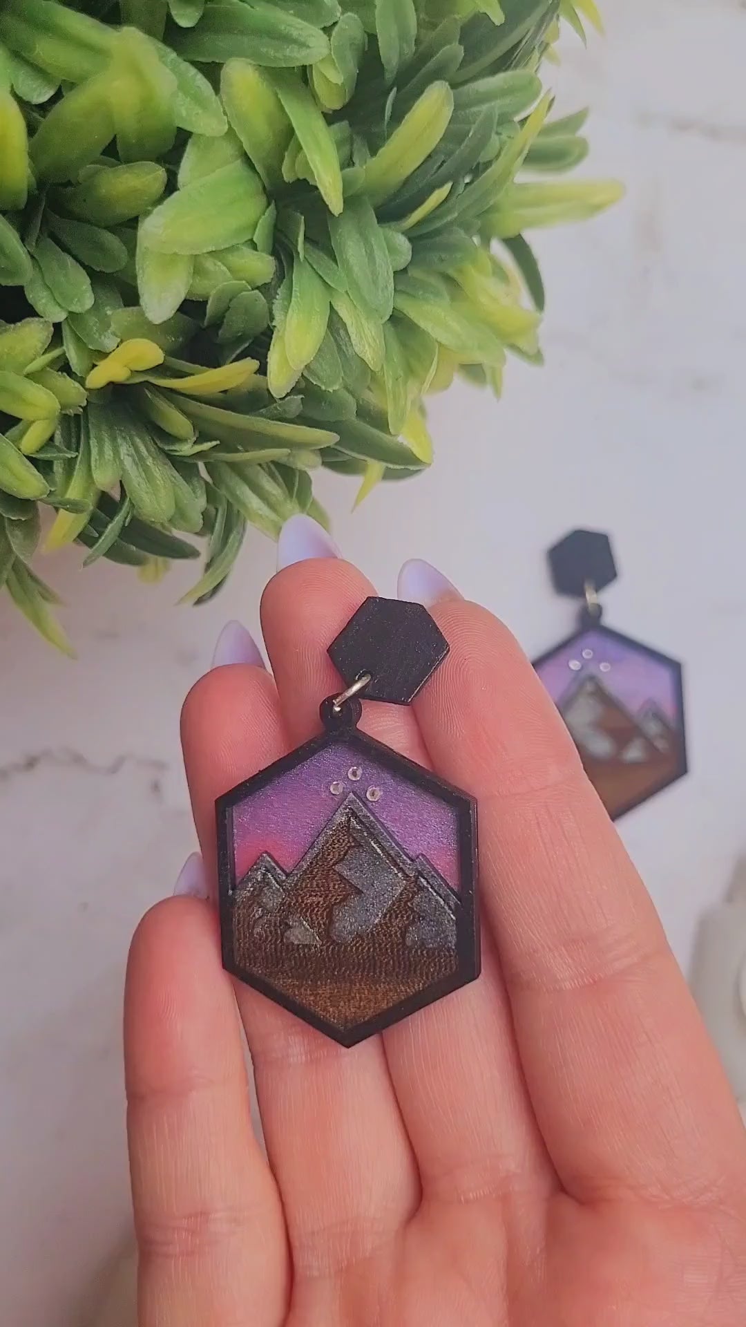 video Close up of night court earring on a marble background surrounded by foliage