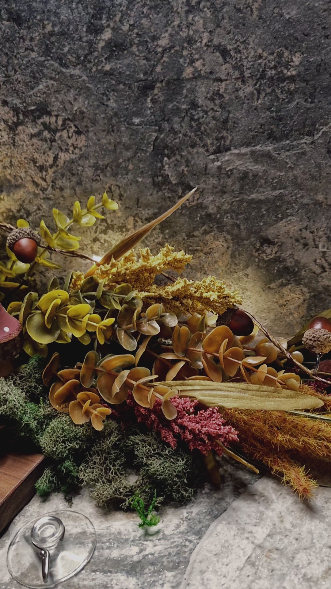 video of Enchanted rose suncatcher on a stone background surrounded by foliage 
