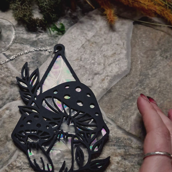 video of mushroom suncatcher on a stone background surrounded by foliage 
