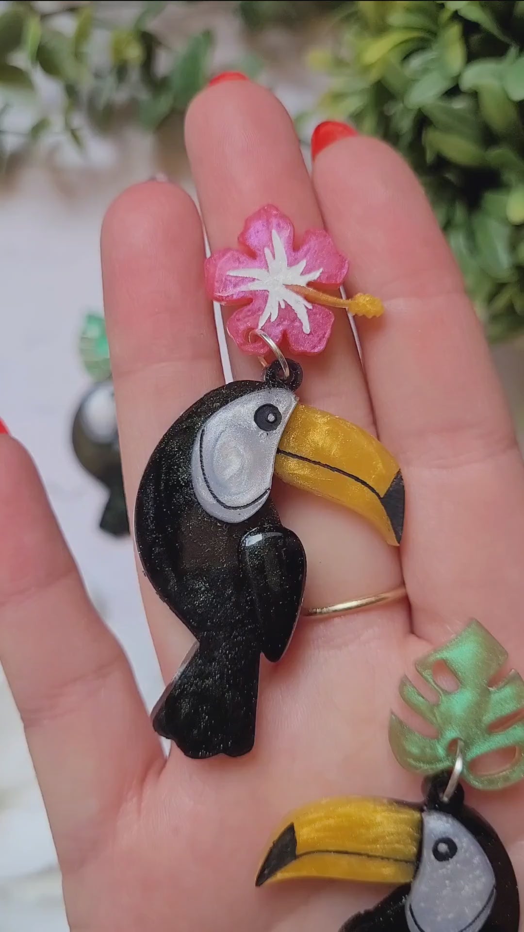 video close up of toucan earrings. 