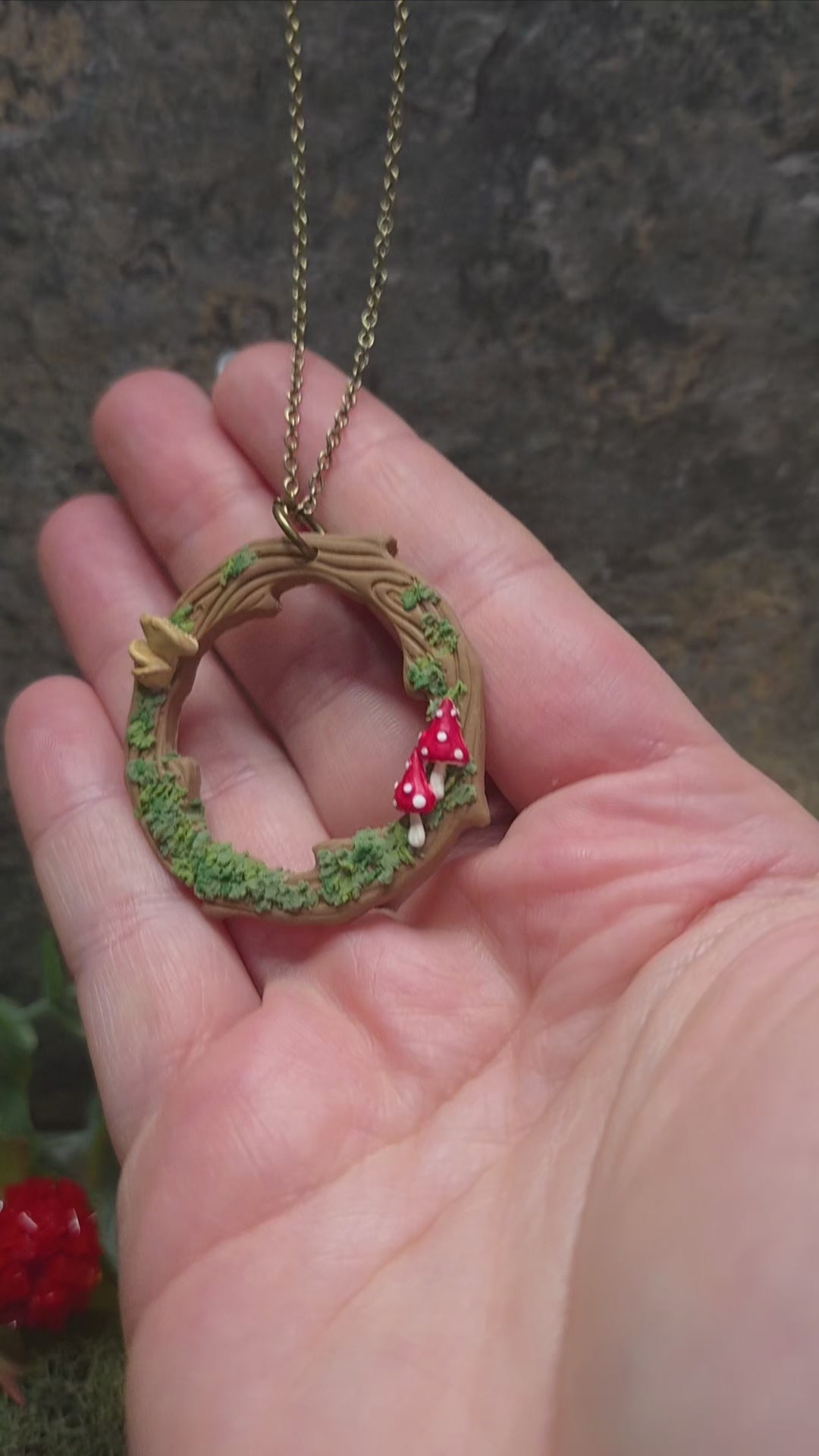 video of Mushroom Wreath Necklace on a stone background surrounded by foliage
