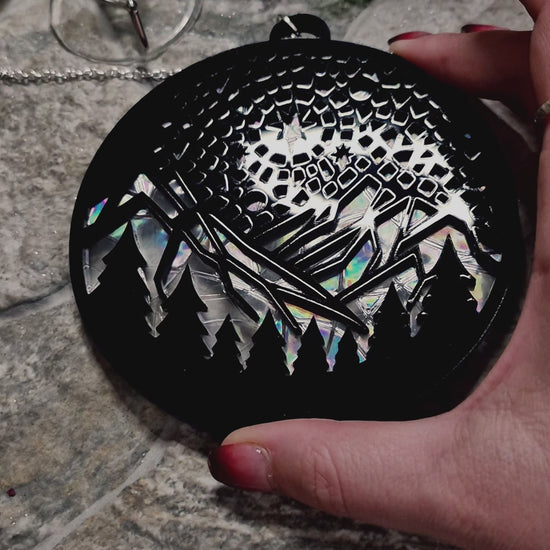 video of starry mountain  suncatcher on a stone background surrounded by foliage 
