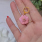 video close up of Baby pink flower earrings on white background with foliage. 