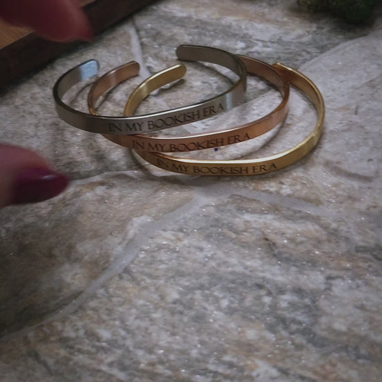 video of In My Bookish Era bracelets on a stone background. 