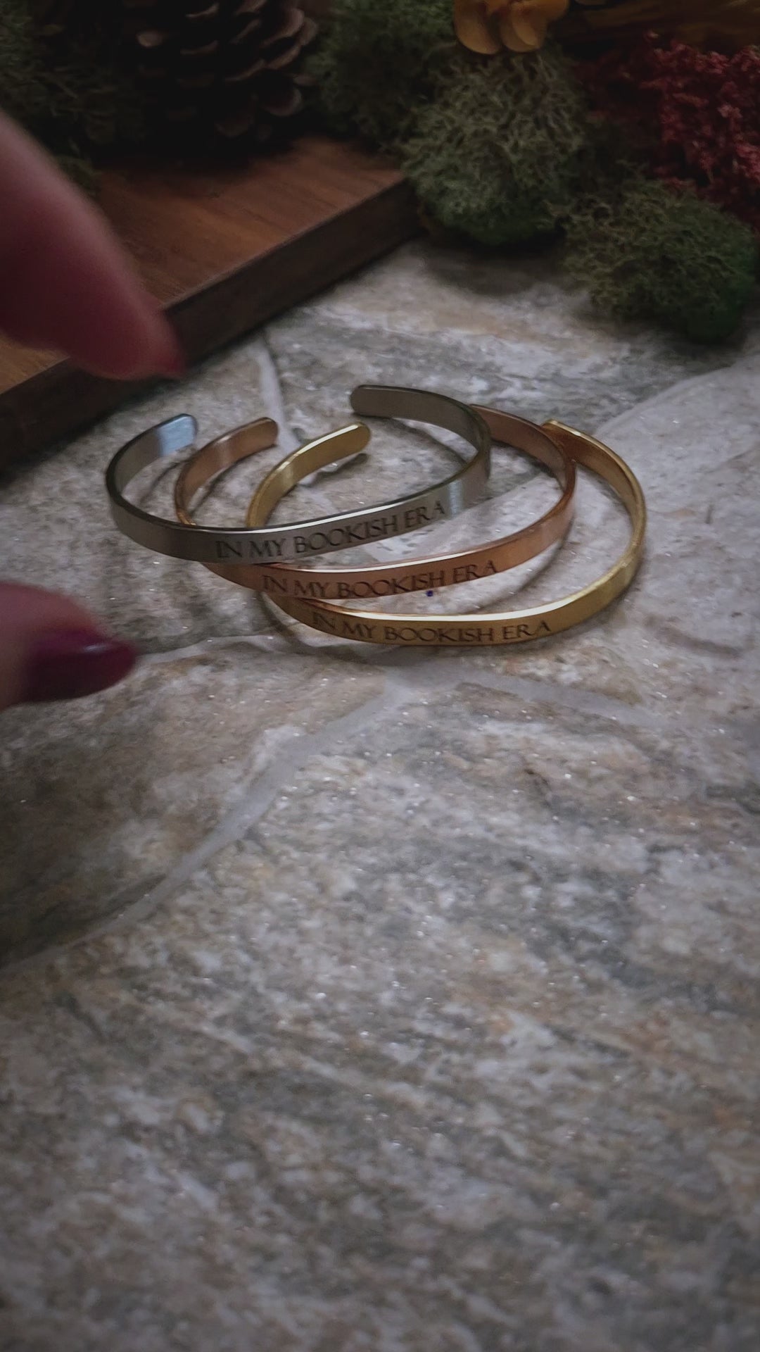 video of In My Bookish Era bracelets on a stone background. 