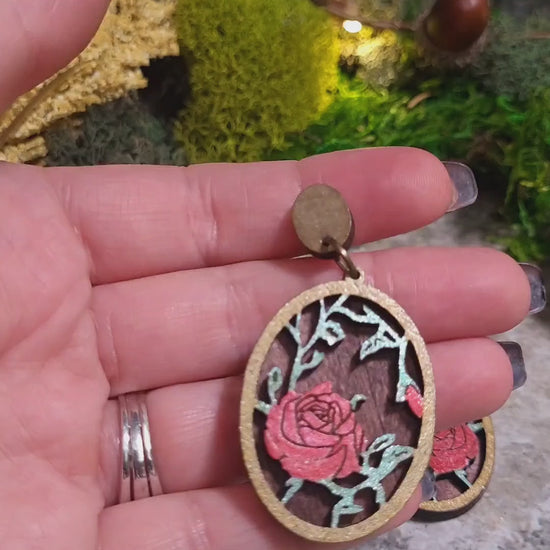 video close up Spring Court Earrings on a stone background surrounded by foliage