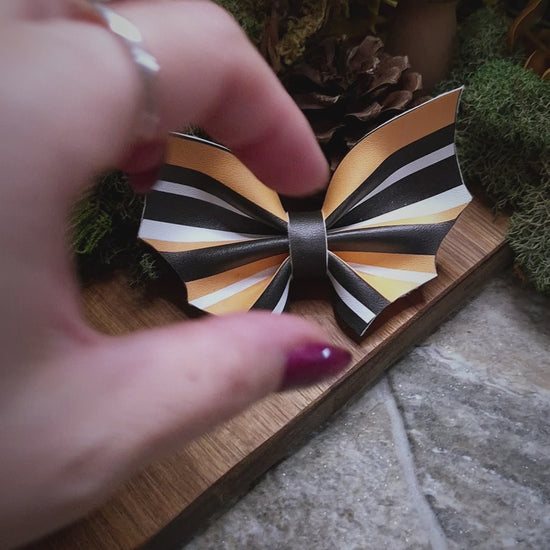 video of halloween stripe bat bow on a wood and stone background 