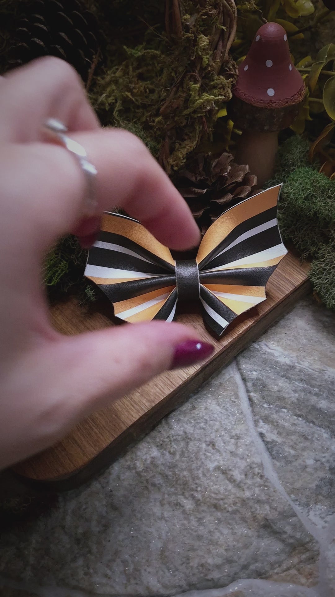 video of halloween stripe bat bow on a wood and stone background 