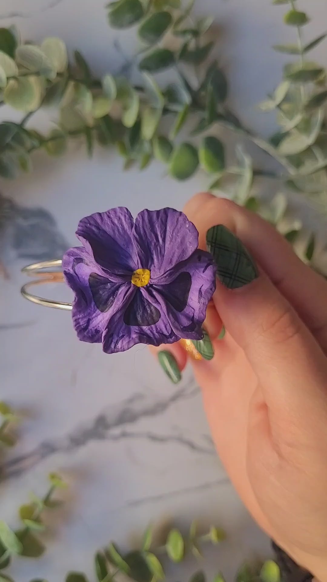 video close up of the dark purple pansy bracelet and how to put it on. 