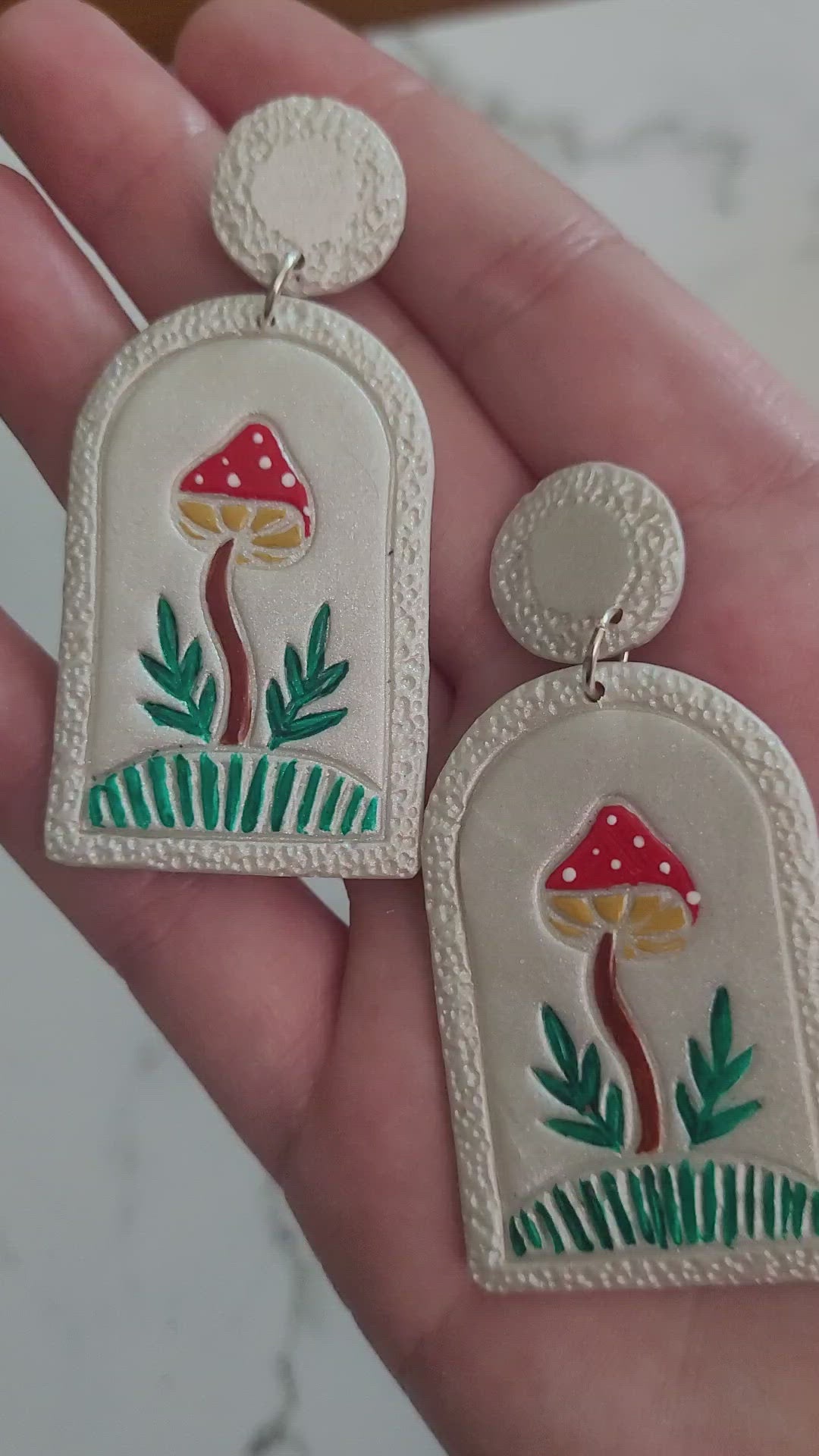 closeup of Pearl earrings with painted mushroom