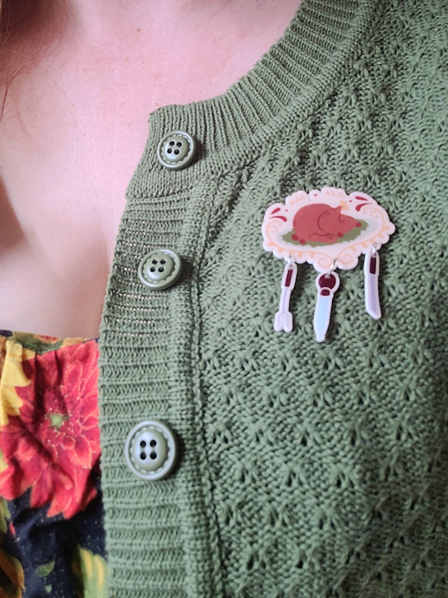 cooked turkey with utensil charm brooch on a green cardigan. 