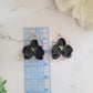 Black and metallic gold polymer clay earrings in the shape of an orchid. 