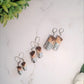 three pairs of burrito shaped earrings in varying sizes made of polymer clay. . 