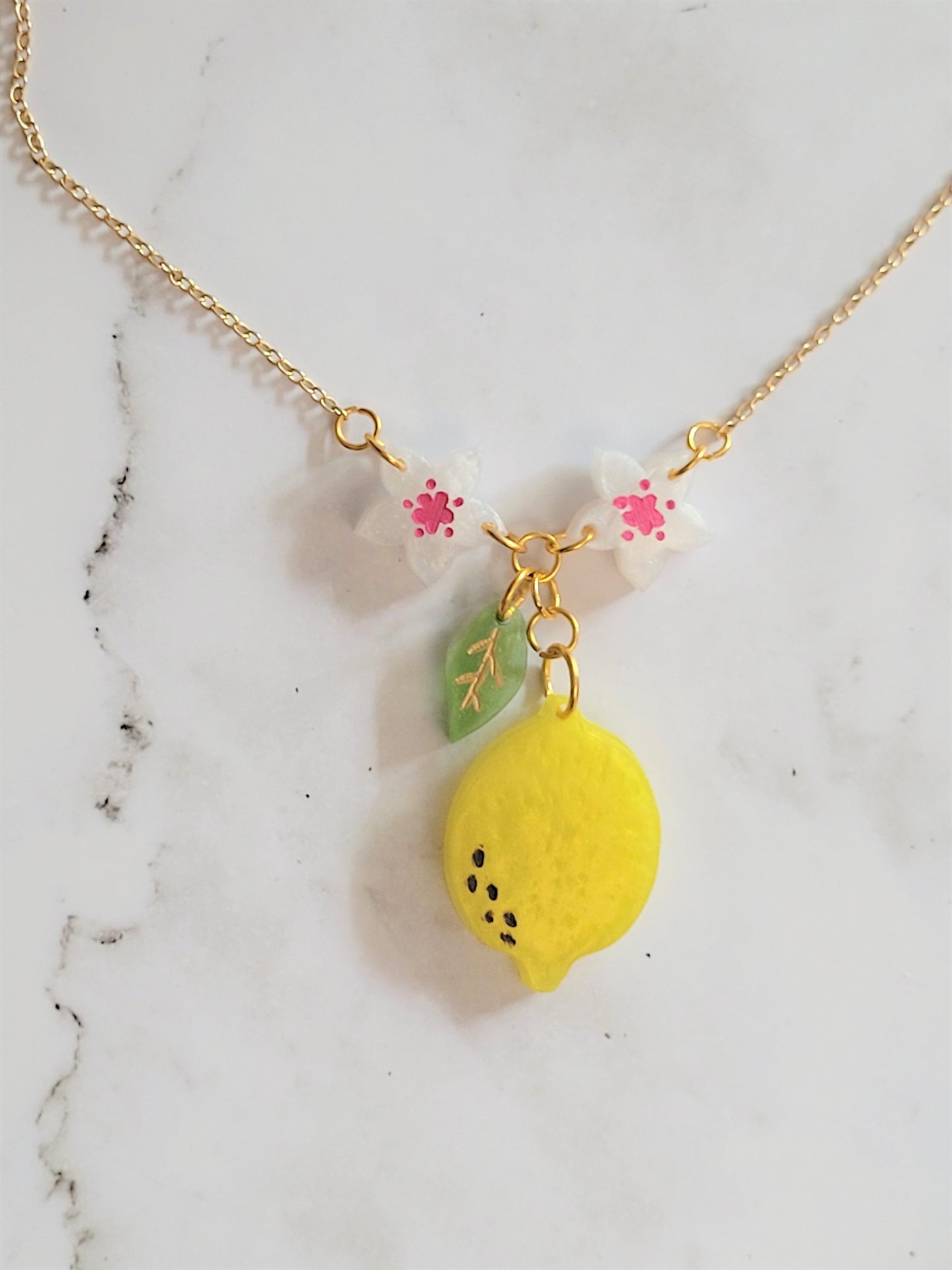 Closeup of lemon blossom resin necklace.
