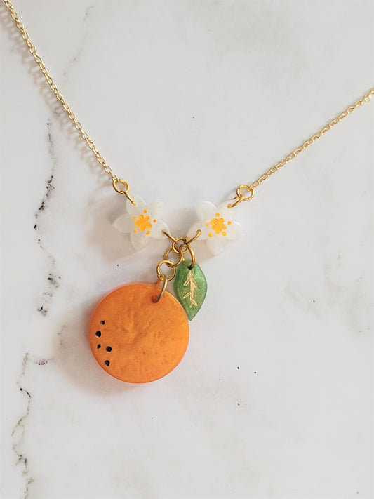 Closeup of orange blossom resin necklace. 