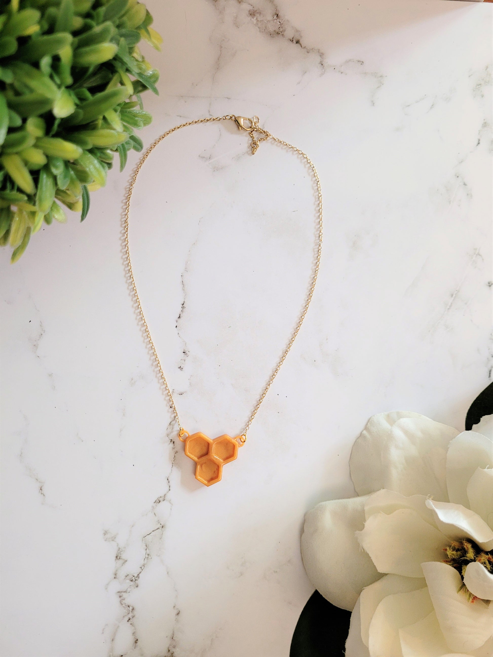 Honeycomb shaped resin necklace  on a white background.